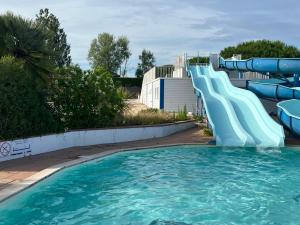 eine Wasserrutsche in einem Pool in einem Resort in der Unterkunft Fleurs du lac studio 2 adultes et 2 enfants avec terrasse vue sur le lac et accès parc aquatique gratuit in Talmont