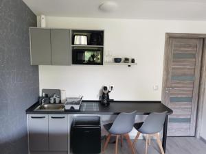 a kitchen with a black counter and some chairs at Giulia Guest House in Sovata