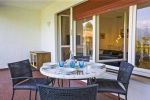 Una mesa con sillas, platos y vasos en un patio. en Casa Magnolia, en Luino