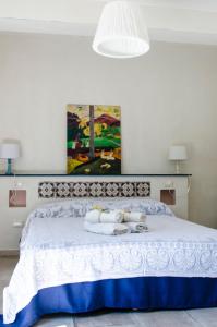 ein Schlafzimmer mit einem weißen Bett und einem Gemälde an der Wand in der Unterkunft Casa Cerqua Landi in Itri