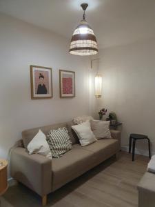 a living room with a couch and a pendant light at Casita en Fontán in Sada