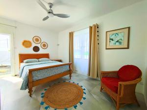 a bedroom with a bed and a chair at Noulakaz Maison proche Belle Mare marché de Flacq in Argy
