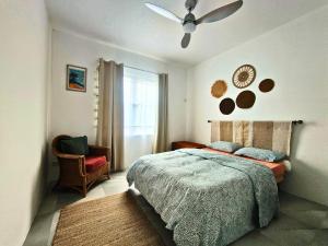 a bedroom with a bed and a ceiling fan at Noulakaz, séjour paisible à 10 min de Belle Mare in Argy