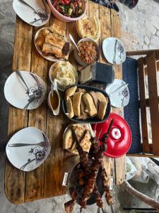 a wooden table with plates of food on it at Vardzia-Chachkari Cottage ,,SEFE" in Gogasheni