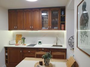 a kitchen with wooden cabinets and a table at Casita en Fontán in Sada