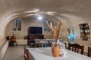 a living room with a table with a vase on it at La perla di tufo in Matera