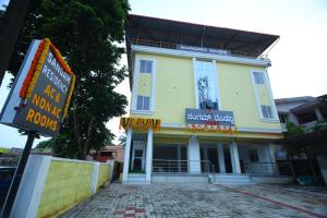 a yellow building with a sign in front of it at SANGAM RESIDENCY Manipal in Manipal