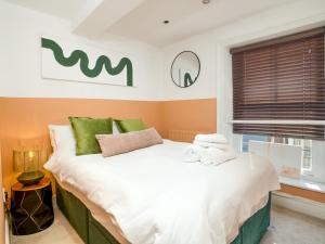 a bedroom with a large white bed with green accents at Stylish Steep Hill Apartment Pass the Keys in Lincoln