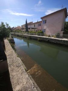 a canal of water with a building and a house at Studio Clair d Eau in Hyères