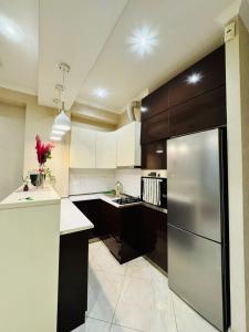 une cuisine avec des armoires blanches et un réfrigérateur en acier inoxydable dans l'établissement ბინა საბურთალოზე 2 საძინებელი #17, à Tbilissi 7 autres photos