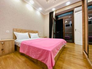 une chambre avec un lit avec une couverture rose dans l'établissement ბინა საბურთალოზე 2 საძინებელი #17, à Tbilissi