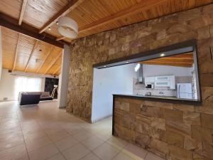 a living room with a stone wall and a counter at Vista Malargüe House in Malargüe
