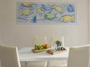 una mesa con 2 sillas y un plato de fruta en Apartment Iris 7- Terza Spiaggia by Interhome, en Golfo Aranci