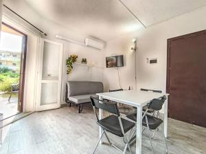 Un comedor con una mesa y sillas blancas. en Apartment Iris 7- Terza Spiaggia by Interhome, en Golfo Aranci 30 fotos más