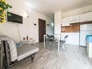 Una sala de estar con un sofá y una mesa con sillas. en Apartment Iris 7- Terza Spiaggia by Interhome, en Golfo Aranci