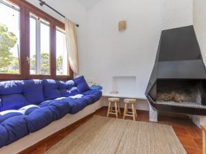 ein Wohnzimmer mit einer blauen Couch und einem Kamin in der Unterkunft Villa Mar by Interhome in L'Ametlla de Mar + 19 Fotos