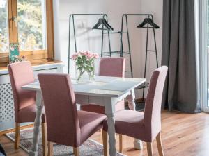 een eettafel met roze stoelen en een vaas met bloemen bij Apartment Anny 2 by Interhome in Zell am See
