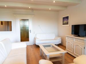 a living room with white furniture and a flat screen tv at Apartment Seethurn by Interhome in Strobl