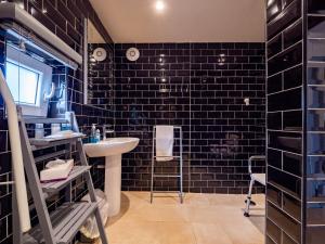 bagno con lavandino e pareti rivestite in piastrelle nere di One bedroom bungalow with private garden at Parkland, near Kingsbridge a Kingsbridge Altre 30 foto