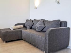a gray couch in a living room with a lamp at Apartment Wohnung 306 Berglick by Interhome in Strobl