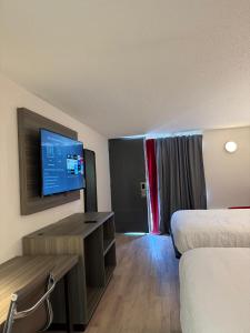 a hotel room with two beds and a flat screen tv at Ramada by Wyndham Lumberton NC North in Lumberton +18 photos