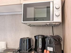 a microwave above a coffee maker and a toaster at Apartment Wohnung 306 Berglick by Interhome in Strobl +28 photos