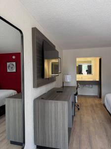 a hotel room with a desk and a mirror at Travelodge by Wyndham Lumberton in Lumberton