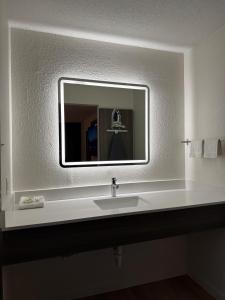 a bathroom with a sink and a mirror at Ramada by Wyndham Lumberton NC North in Lumberton