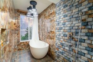 a bathroom with a bath tub in a brick wall at Ocean Villa Ukulhas Hotel & Spa in Ukulhas +113 photos