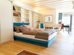 a bedroom with a large bed with a blue headboard at Apartment Penthouse Deluxe Galerie 2 stöckig by Interhome in Strobl
