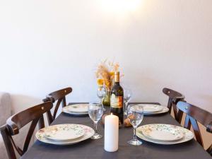un tavolo con una bottiglia di vino e una candela di Apartment Les Dryades 6 by Interhome a Villars-sur-Ollon Altre 13 foto