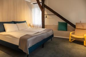 a bedroom with a bed and a chair and a window at Eda7 Boutique Rooms in Sarajevo