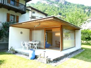 a glass extension of a house with a table at Holiday Home Casa Calanca by Interhome in Grono