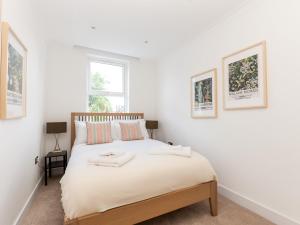 a bedroom with a bed with two towels on it at Pass the Keys Stunning 4Bed Oasis in Kingston With Parking in Kingston upon Thames