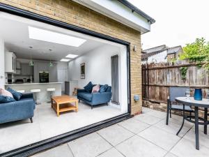a patio with two blue chairs and a table at Pass the Keys Stunning 4Bed Oasis in Kingston With Parking in Kingston upon Thames