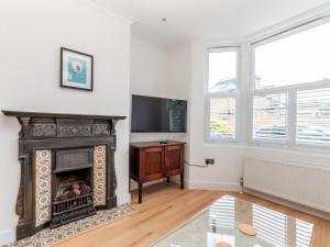 a living room with a fireplace and a television at Pass the Keys Stunning 4Bed Oasis in Kingston With Parking in Kingston upon Thames