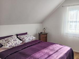 a bedroom with a purple bed and a window at Holiday Home Casa Lenka by Interhome in Zlaté Hory