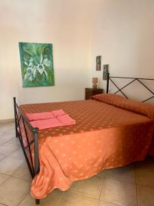 a bedroom with a bed with orange sheets and a table at Affittacamere Dodo - Borgo di Filetto in Filetto +105 photos
