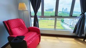 a red chair in a room with a large window at PPAM Seruling Presint 5, Putrajaya 4BR with PICC and Garden View, 62200 Putrajaya 
