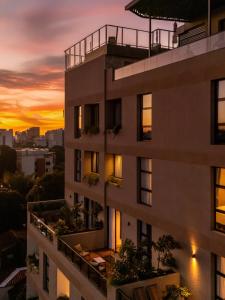 um edifício de apartamentos com o pôr-do-sol ao fundo em Divina Tower Apart Hotel em Assunção