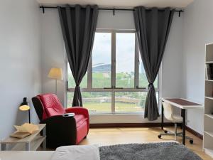 a bedroom with a red chair and a large window at PPAM Seruling Presint 5, Putrajaya 4BR with PICC and Garden View, 62200 Putrajaya  +27 photos