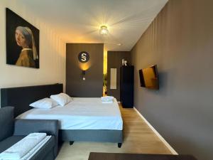 a small room with a bed and a couch at Central Studios in The Hague
