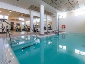a swimming pool with blue water and a gym at Apartment Collection View Free Spa & Padel by Interhome in Torrox Costa