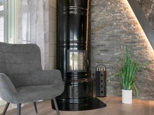 ein Wohnzimmer mit einem Stuhl neben einer Ziegelwand in der Unterkunft Holiday Home Tervaranta by Interhome in Ähtäri + 22 Fotos