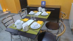a black table with chairs and white dishes on it at Hotel La Encina Celorio Llanes PARKING in Llanes