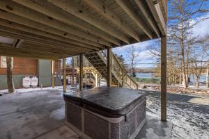a covered porch with a wooden roof with a trunk at New Luxury Lakeview Retreat with Lake Access, HotTub, Game Room, Sleeps 28 in Lake Harmony