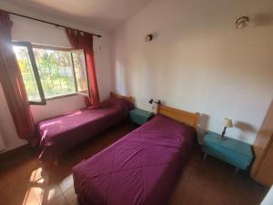 ein Zimmer mit zwei Betten und einem Fenster in der Unterkunft Casa en Mar de Ajò, barrio San Rafael in Mar de Ajó