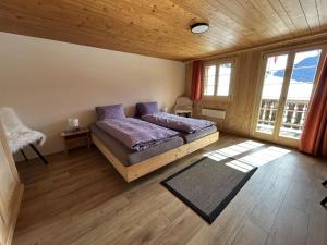 una camera da letto con letto e cuscini viola di Apartment Alpenchalet Haldeli by Interhome a Gstaad