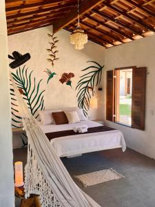 a bedroom with a hammock in a room at Zema Bangalôs in Trairi
