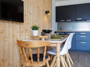 a kitchen with a table with chairs and a tv at Studio Beau Soleil G11 by Interhome in Veysonnaz